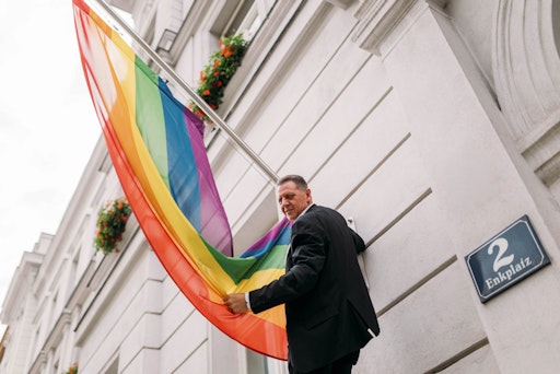 Bezirksvorsteher Thomas Steinhart hisst die Regenbogenfahne vor
dem Amtshaus in Simmering.