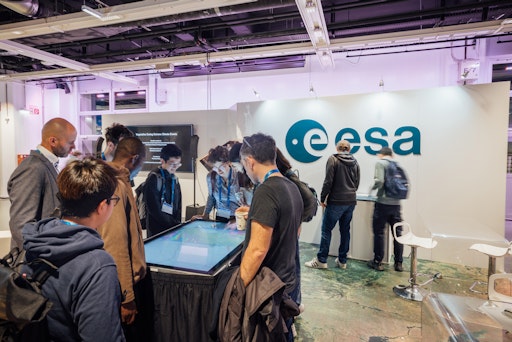  Menschen beim Ausstellungsstand der ESA im Austria Center Vienna