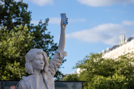 Vorschau Bild von Am Eingang zur Ringstraße begrüßt die Besucher*innen die rund
vier Meter hohe „Handyfreiheitsstatue“ von Drei. In Anlehnung an die
berühmte Freiheitsstatue symbolisiert die Skulptur die neue
„Handyfreiheit“ des Mobilfunkanbieters – ein innovatives Konzept für
den nachhaltigen und flexiblen Zugang zu Top-Smartphones. In
Kooperation mit Drei ist die Statue noch bis einschließlich 14. Juli
auf dem Rathausplatz ausgestellt. Besonders abends lädt sie als
markantes Fotomotiv dazu ein, festgehalten zu werden.