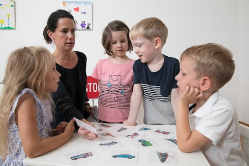 Vorschau Bild von Eine Verkehrstrainerin erklärt drei Kindern spielerisch
verschiedene Verkehrsmittel, typische Geräusche und das richtige
Verhalten bei Zebrastreifen, Ampel & Co.