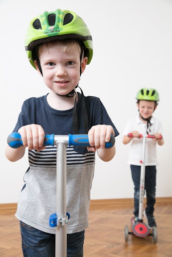 Vorschau Bild von Zwei Buben fahren mit ihren Scootern und üben spielerisch
sicheres Verhalten im Straßenverkehr.
