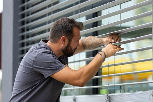 Sonnenschutztechniker montiert Raffstore