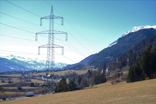 Ein Strommast im Vordergrund und im Hintergrund ein
schneebedeckter Berg