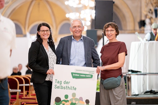 Vorschau Bild von v.l.n.r.: Christiane Ladinig, MA (fachliche Leitung der
Selbsthilfe-Unterstützungsstelle SUS Wien), Dennis Beck
(Geschäftsführer der Wiener Gesundheitsförderung – WiG) und Mag.a
Martina Daim (fachliche Leitung der Selbsthilfe-Unterstützungsstelle
SUS Wien) freuten sich über die interessierten Besucher*innen beim
Tag der Selbsthilfe im Wiener Rathaus.