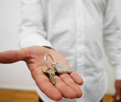 Eine Person hält einen Schlüssel in der Hand und steht vor einer
Haustür. Das Gesicht ist nicht sichtbar. Symbolfoto zum Thema
Türöffnung, Schlüsseldienst und Sicherheit im Alltag.