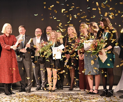 Wettbewerbsgewinnerin Alena Kogler wird auf der Bühne von der
Jury und den Ehrengästen gefeiert.