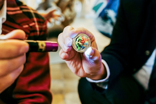 Vorschau Bild von Im Licht der UV-Lampe ändert die Münze ihre Farben