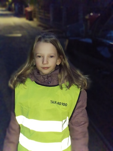 Dieses Mädchen trägt eine reflektierende Warnweste und wird im
Straßenverkehr leichter gesehen.
