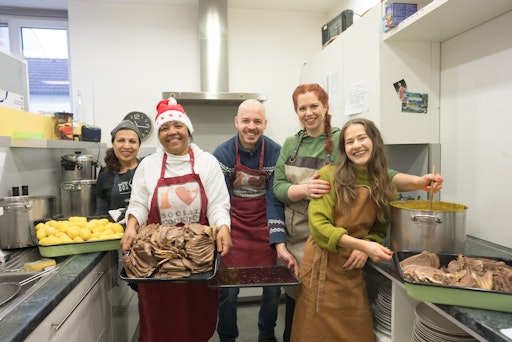 Vorschau Bild von (v.l.) Maria Margarita Rauwarter, Mouna Haji Ahmad, David Wallner
(dm), Jacqueline Wasserbauer (dm) und Anja Fierlinger (dm) zusammen
in der Küche mit dem fertigen Essen vor der Essensausgabe.