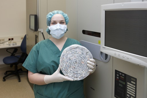  Foto mit Mitarbeiterin, welche Tabletten verblistert bzw. einen
Rolle mit verbliterten Tabletten in der Hand hält.