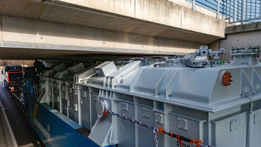 Vorschau Bild von Mit nur fünf Zentimeter Spielraum und unter permanenter
Überwachung der Einweiser fährt der Trafotransport unter einer
Eisenbahnunterführung durch.