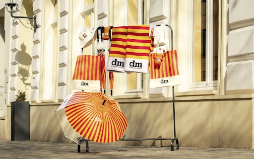 Vorschau Bild von Ab 8. April sorgen zwei Paar klassische Tennissocken mit
Streifen, ein gemütliches Strandtuch, eine Cap und ein lässiger
Bucket Hat für Retro-Vibes. Wenn das Wetter nicht mitspielt, kommt
der transparente Regenschirm mit rot-orangen Streifen zum Einsatz.
Und der tägliche Einkauf bei dm wird mit der Vintage-Baumwolltasche
zum stylischen Statement.