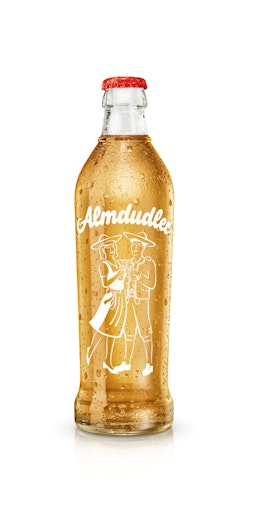 Vorschau Bild von Die ikonische Almdudler Formflasche ist Kult – genauso wie die
Alpenkräuterlimonade selbst. Dahinter steht eine besondere
Liebeserklärung. Denn Erwin Klein kreierte den spritzigen
Durstlöscher mit natürlichen Alpenkräutern einst aus Liebe zu seiner
Frau Ingrid und überreichte ihr zum Hochzeitstag den ersten
Almdudler in der Glasflasche. Abgefüllt am 17. Oktober 1957, zeigte
sich auf der kultigen Mehrweg-Glasflasche schon damals das
sympathische Almdudler Trachtenpärchen Marianne & Jakob, das bis
heute als Markenzeichen auf allen Almdudler-Produkten zu finden ist.