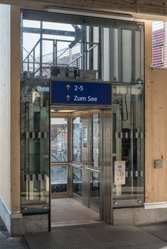 Vorschau Bild von Aufzug von der Seite mit der offenen Türe. Im Inneren ein Screen
mit Infodaten. Außen Ansicht Bahnsteigzugangsinformationen.