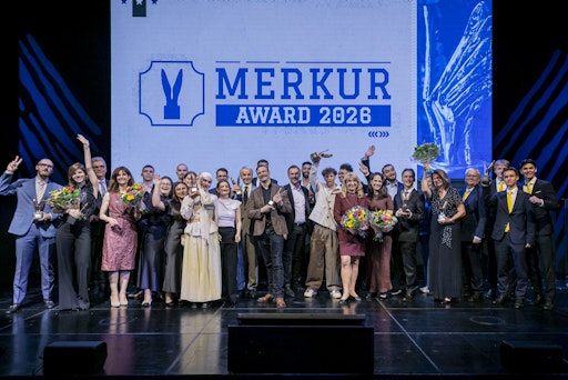 Die glücklichen Gewinner:innen des Merkur Awards gemeinsam mit
den namhaften Laudator:innen auf der Bühne der Grand Hall am Erste
Bank Campus.