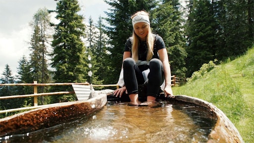 Mädchen beim Brunnen Urlaub auf der Alm Kärnten