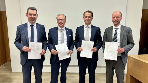 Die vier Vorstände der beiden Banken mit dem unterzeichneten
Verchmelzungsvertrag.