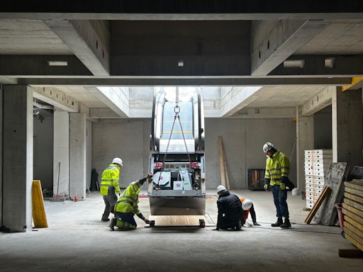 Monteure arbeiten an einer Fahrtreppe bei offenem Dach
