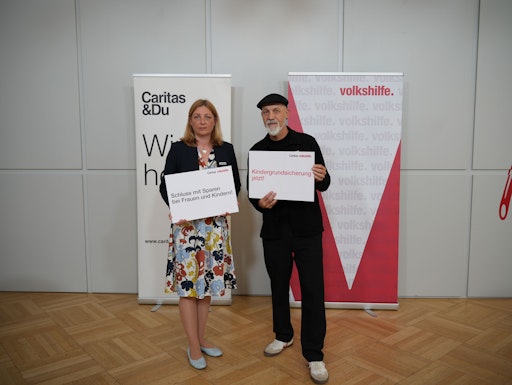 Nora Tödtling-Musenbichler / Präsidentin Caritas Österreich und
Erich Fenninger / Direktor Volkshilfe Österreich halten Forderungen
auf Schildern hoch: "Schluss mit Sparen bei Frauen und Kindern!" und
"Kindergrundsicherung jetzt!"