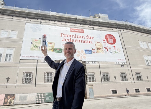 Vorschau Bild von Florian Schwap vor dem SalzburgMilch Megabanner am Domplatz