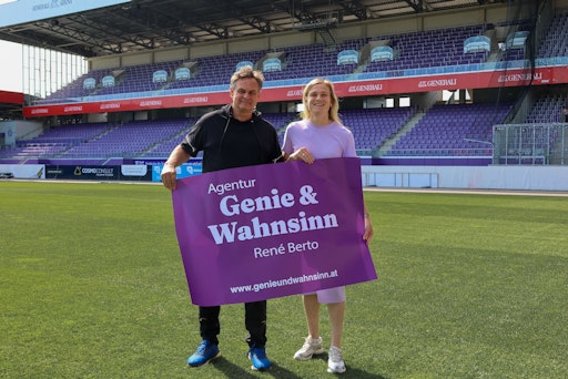 Vorschau Bild von Eine Frau und ein Mann in einem Fußballstadion mit einem
Transparent in der Hand