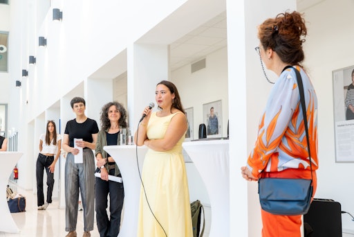 Vorschau Bild von Dilara Gündüz spricht bei der Eröffnung ihrer Ausstellung „Es
kamen Menschen an“ an der Pädagogischen Hochschule Wien.
