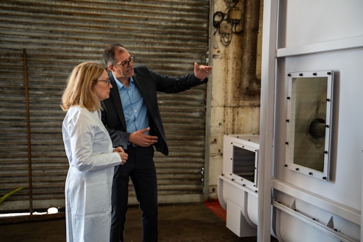 Vorschau Bild von Nancy Sanders und Herwig Thiel vor dem Kunststoffzerkleinerer der
Pilotanlage Rewinplast