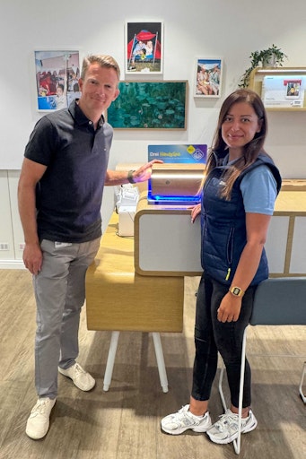 Drei CCO Günter Lischka und Drei Shop Mitarbeiterin mit der
UV-Reiningsbox im Drei HandySpa im Drei Shop.