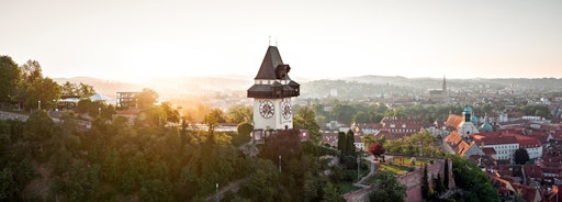 Uhrturm auf dem Schlossberg bei Sonnenuntergang mit Blick über
die Grazer Altstadt.