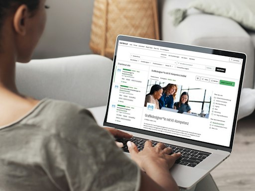 Vorschau Bild von Eine Frau sitzt an einem Laptop und sieht sich ein Stelleninserat
mit dem Titel "Grafikdesigner*in mit KI-Kompetenz (m/d/w)" an