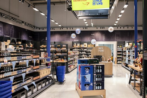 Vorschau Bild von Der Getränkehändler Ammersin eröffnet am 28. September 2026
seinen neuen Flagship Store in der Josef-Strebl-Gasse 6 in Brunn am
Gebirge im Soft Opening. Ab 8. Oktober warten vier Wochenenden mit
Eröffnungsangeboten. Im Bild: eine Verkaufsgang-Ansicht des neuen
Stores mit Bierkisten, Info Point und Sortimentsregalen.