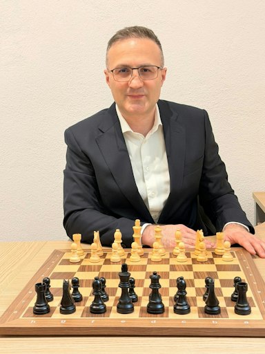Gründer der Vienna Chess School: Schach-Großmeister David
Shengelia vor einem Schachbrett.
