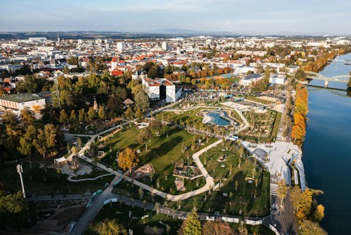 Vorschau Bild von Aus der Vogelperspektive wird sichtbar, wie Wels mit seinen sechs
Gartenwelten Schritt für Schritt zur Stadt der Gärten wächst. Eifrig
wird gebaut, gestaltet und gepflanzt. Im Bild: Volksgarten und
Traungarten.