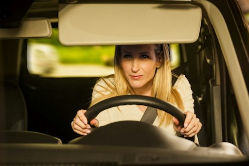 Frau im Auto, von der Sonne geblendet