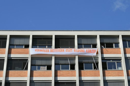,,Kürzen ist keine Kunst". Banner aus den Fenstern der
Angewandten am Oskar-Kokoschka-Platz.