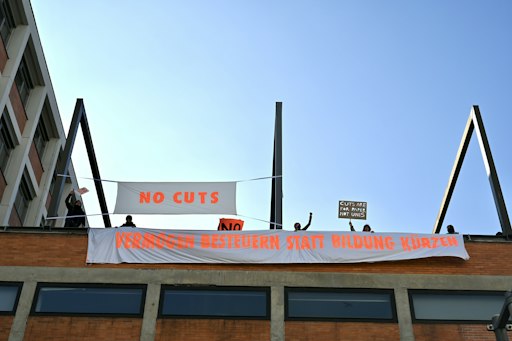 Vorschau Bild von Studierende protestieren mit Bannern auf dem Dach der Universität
für angewandte Kunst.